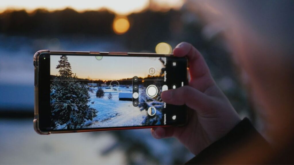 Persona tomando una fotografía con la cámara de un teléfono inteligente moderno